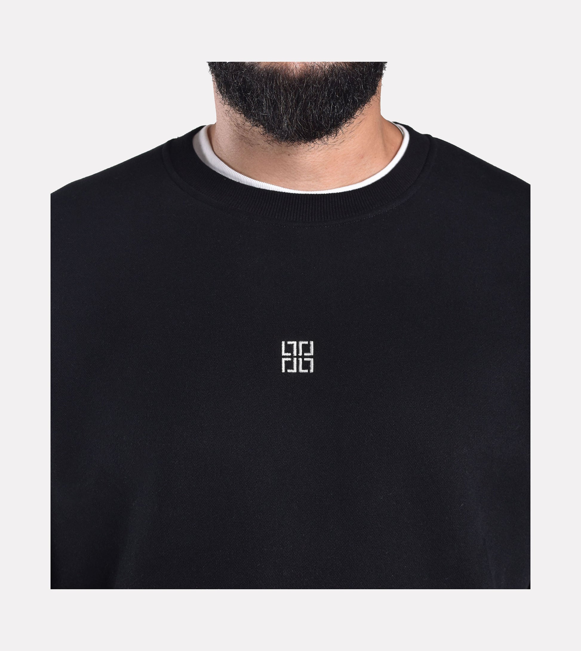 Close-up front view of LIMITED. black oversized sweatshirt with small white logo embroidery