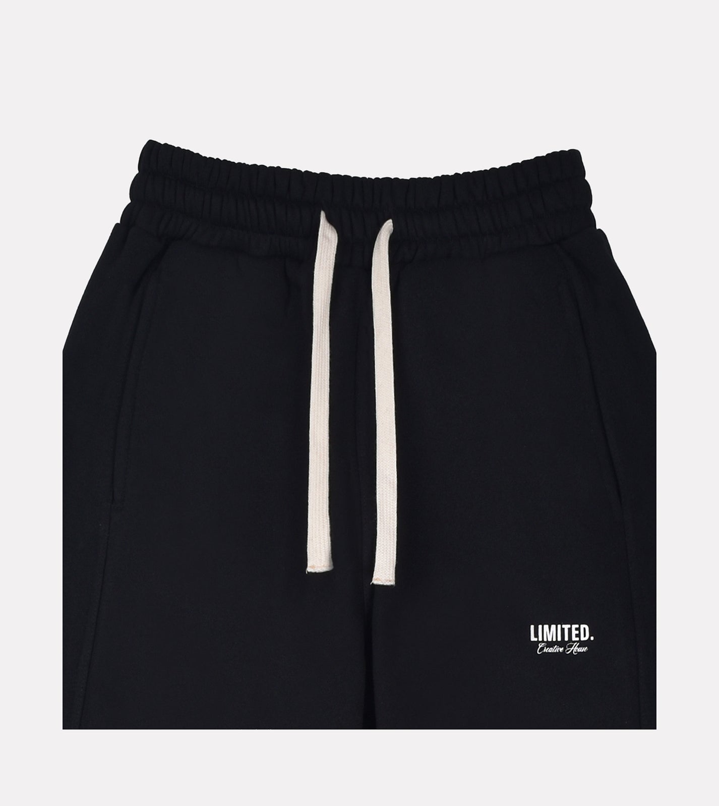 Close-up of LIMITED. mens black sweatpants with printed branding and off-white drawstrings