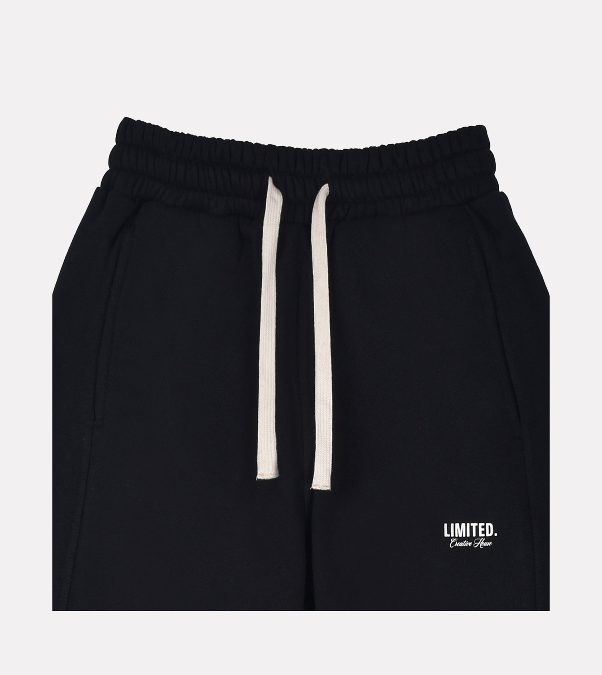 Close-up of LIMITED. mens black sweatpants with printed branding and off-white drawstrings