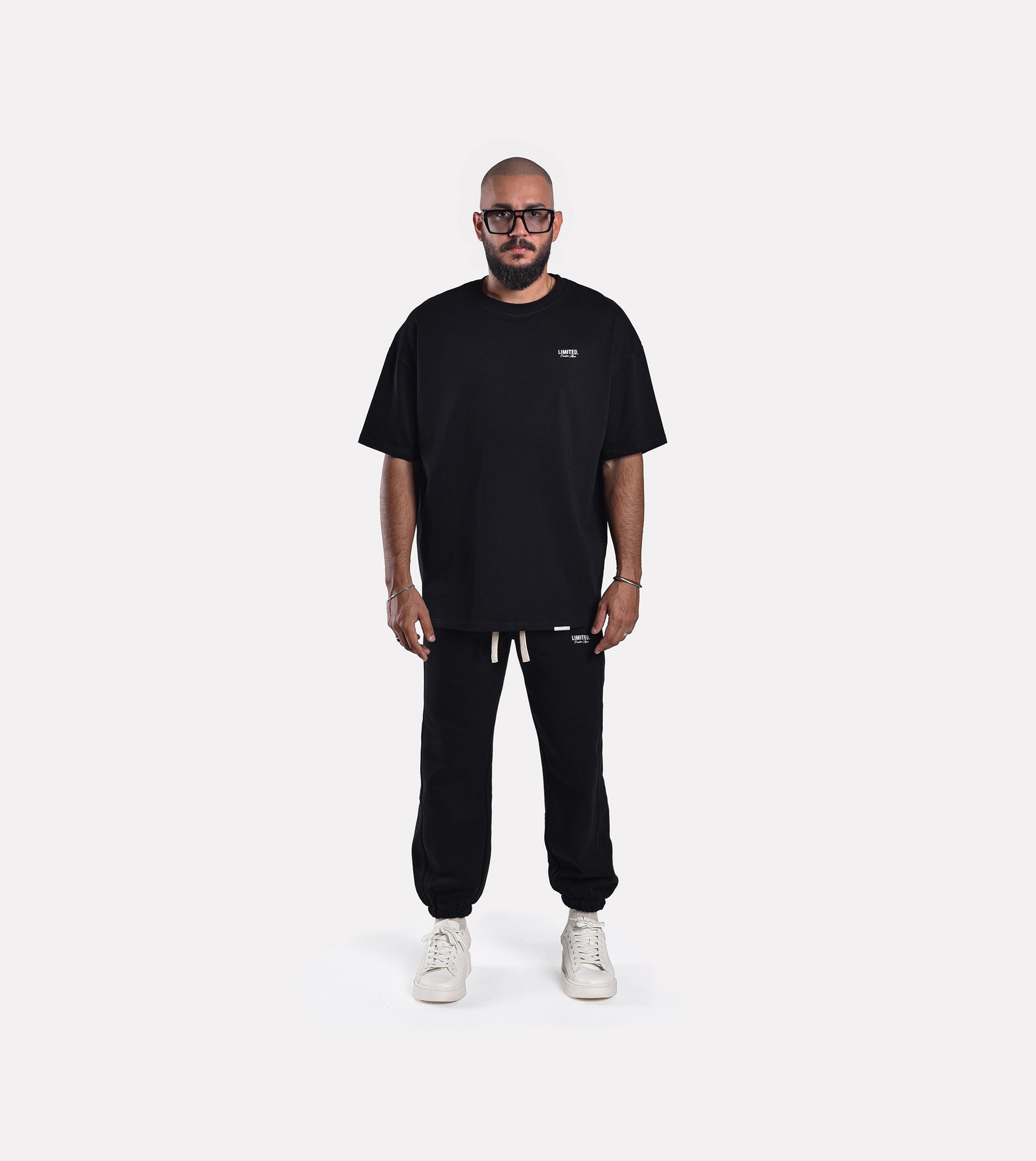 Front view model wearing LIMITED. Oversized mens t-shirt in black with small white branding on the left chest.