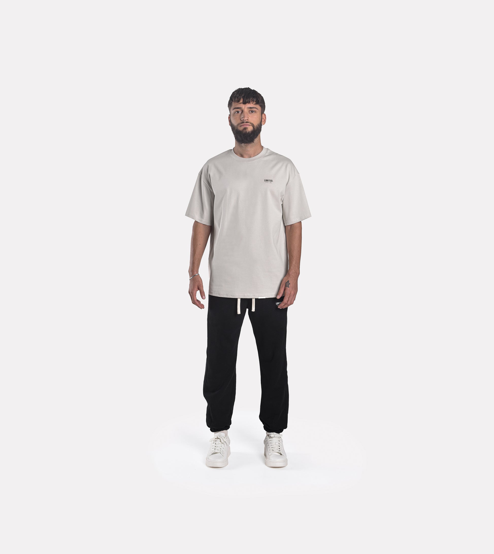 Front view model wearing LIMITED. Oversized mens t-shirt in whisper grey with small black branding on the left chest.